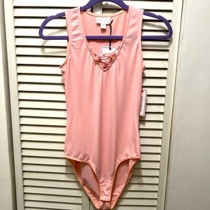 Pink body suit straps across chest . Very cute and sexy